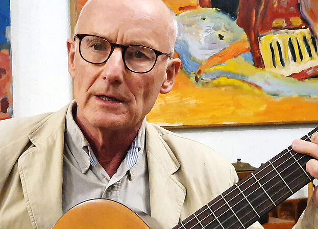 Ekkehard Maaß mit Gitarre vor Gemälde